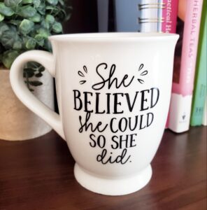 She believed she could so she did white coffee cup. Natural Background with Books- Gift Guide for Coffee or Tea Lovers